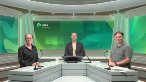 Three people in a modern studio setting with microphones, seated at a triangular desk. The background displays the iBABS logo.